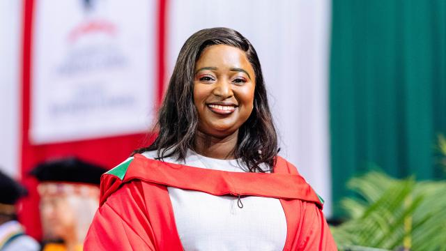 Black woman wearing PhD graduation gown