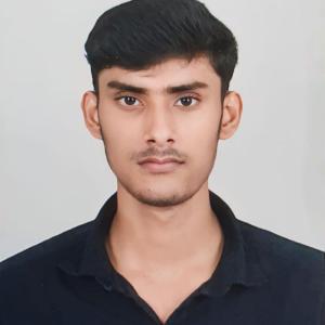 Headshot of Aumkesh against a plain light background, wearing a black collared shirt.