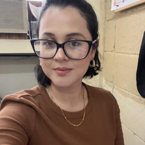 Portrait photo of Ingrid Lorena Díaz Ramírez, a Honduran physicist and university lecturer, wearing glasses and a brown blouse in an academic office setting.