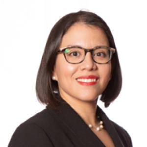 Professional portrait of a smiling woman wearing formal attire.