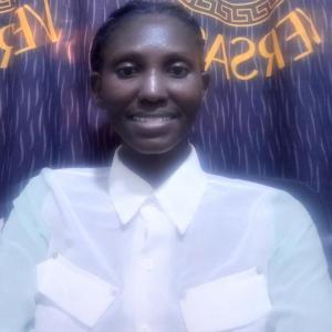 a lady sits on a chair with her back facing the window blind