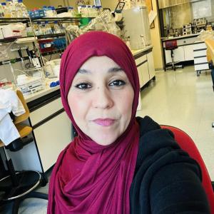 Professional headshot of Halla Elshwekh, a Libyan PhD candidate in Cancer Genomics and Molecular Genetics.