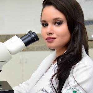 Biomedical scientist Marielena V. Saivish wearing a lab coat in a laboratory setting.