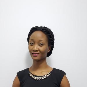 Mrs Kelly G. Mugisha smiling before a presentation