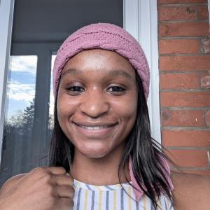 Pink head piece, hand in picture, smiling