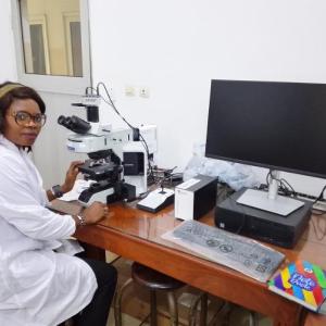 Dr. Felicitas N. Afiukwa getting ready to view microorganisms in a microscope