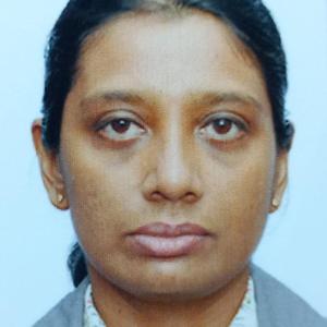 Headshot of a woman with tied-back dark hair, wearing a collared shirt and blazer, facing forward against a plain background.