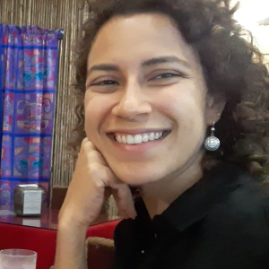 A smiling person with curls