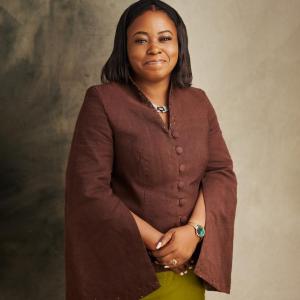 Professional headshot of Omosola Bolarin, smiling, wearing formal attire, against a neutral background.