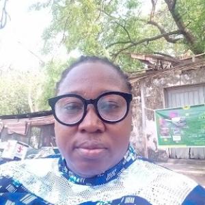 An oblong face, wearing a pair of glasses and a blue and white dress