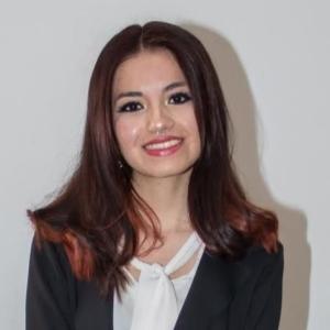 Raquel Calderon, smiling, headshot in formal clothing.
