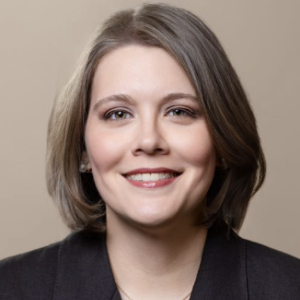 Image shows a woman staring at the camera while smiling