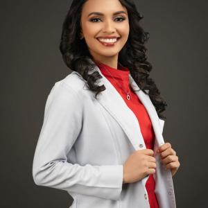 Retrato profesional de Eyleen Montero Romero, científica y dietista, sonriendo y vistiendo una bata blanca de laboratorio sobre un fondo neutro
